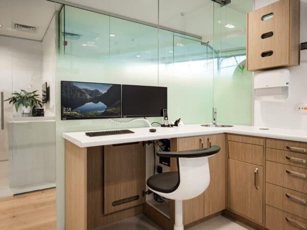 Treatment room with glass mounted monitors and hidden computer