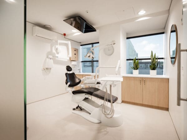 Treatment room showing ceiling TV above dental chair